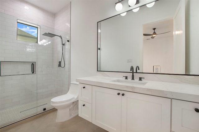 bathroom featuring vanity, a shower with door, tile patterned flooring, ceiling fan, and toilet