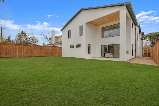 rear view of property with a lawn and a patio