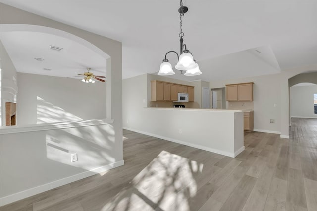 interior space featuring pendant lighting, light hardwood / wood-style flooring, ceiling fan, and light brown cabinets