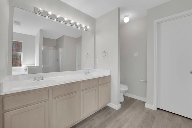 bathroom with vanity, hardwood / wood-style flooring, toilet, and a shower