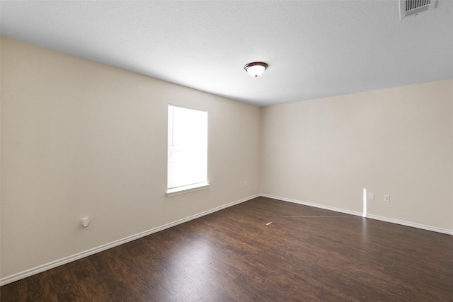 unfurnished room with dark wood-type flooring