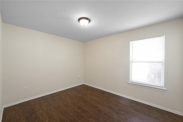 unfurnished room featuring dark wood-type flooring