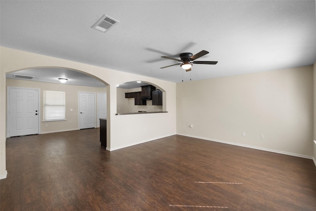 unfurnished living room with a textured ceiling, dark hardwood / wood-style flooring, and ceiling fan