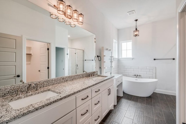 bathroom with vanity and shower with separate bathtub