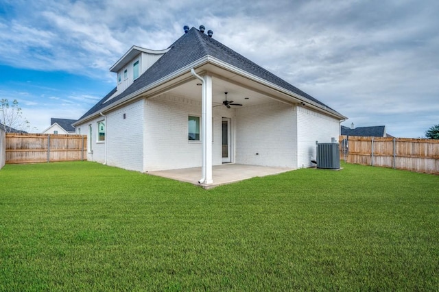 rear view of house with ceiling fan, a patio area, a yard, and central AC