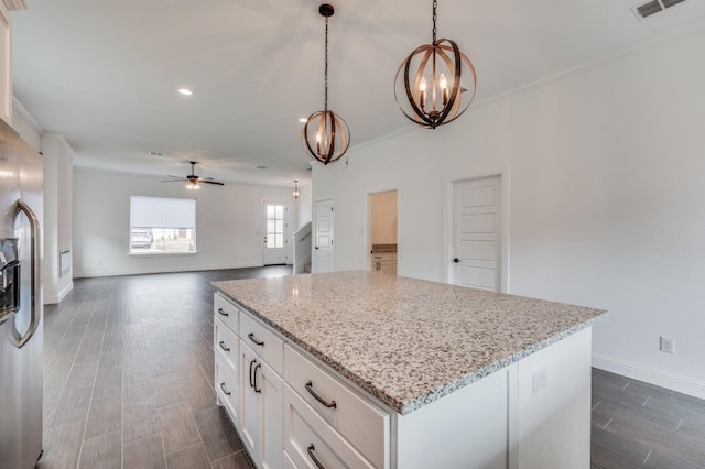 kitchen with pendant lighting, white cabinets, ceiling fan with notable chandelier, light stone countertops, and stainless steel fridge with ice dispenser