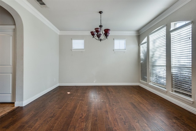 empty room with dark hardwood / wood-style floors, ornamental molding, and a chandelier