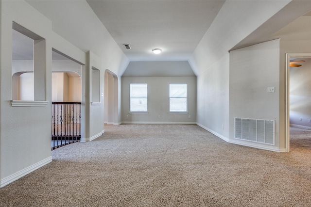 carpeted empty room featuring lofted ceiling