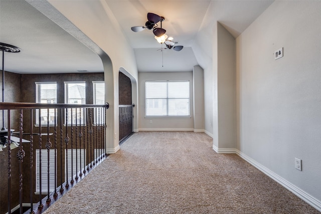 corridor with lofted ceiling, carpet floors, and a wealth of natural light