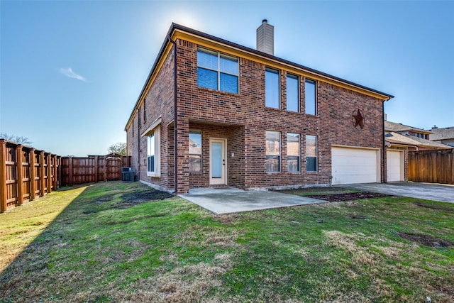 back of house with a yard, a garage, central AC unit, and a patio area