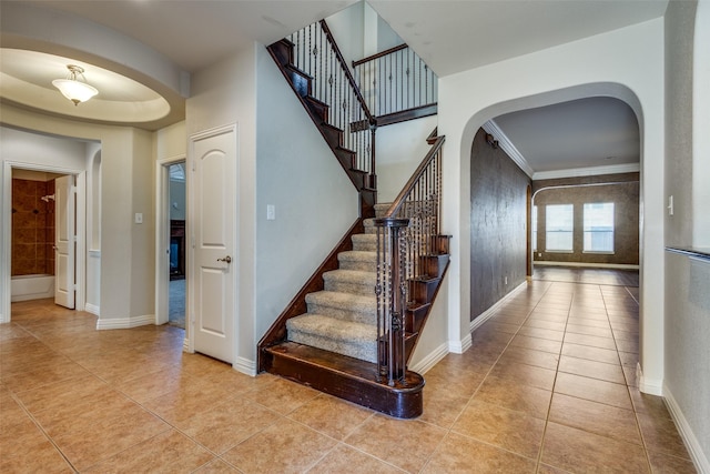 staircase featuring tile patterned flooring and crown molding