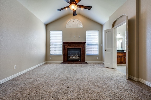 unfurnished living room with light carpet, vaulted ceiling, and ceiling fan