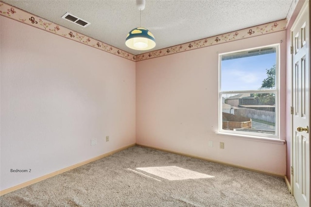 empty room featuring carpet and a textured ceiling