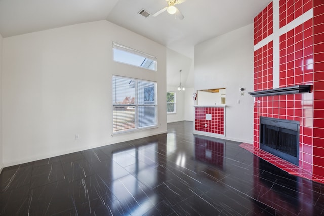 unfurnished living room featuring a fireplace, high vaulted ceiling, and ceiling fan with notable chandelier