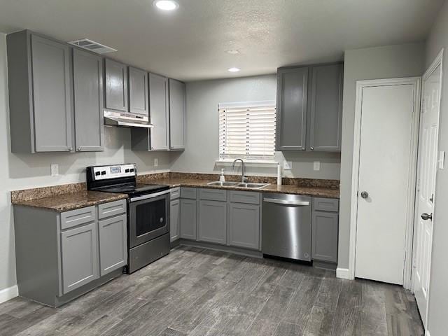 kitchen featuring dark hardwood / wood-style floors, gray cabinets, sink, and stainless steel appliances