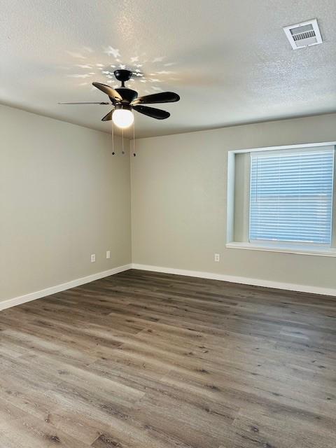 unfurnished room with dark hardwood / wood-style floors and a textured ceiling