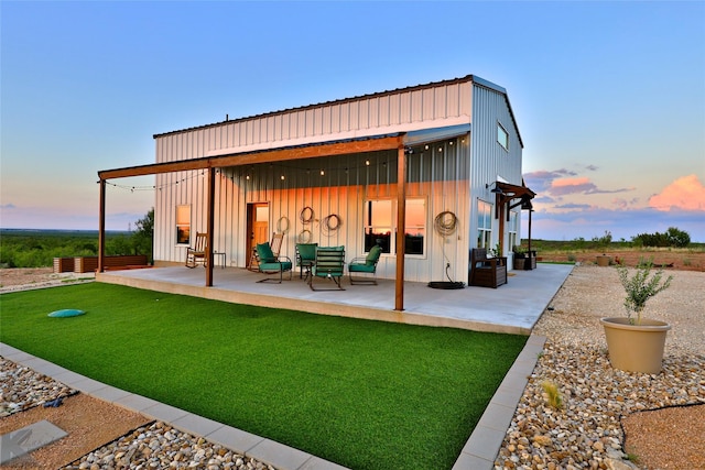 back house at dusk featuring a patio