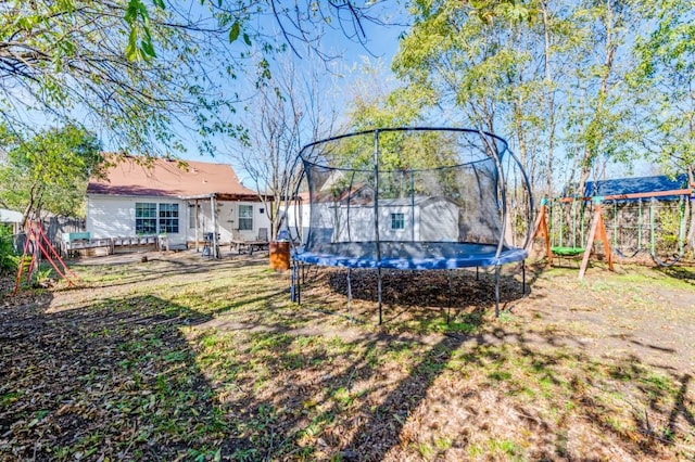 view of yard with a playground and a trampoline