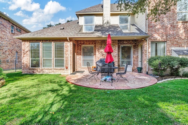 rear view of property featuring a patio and a lawn