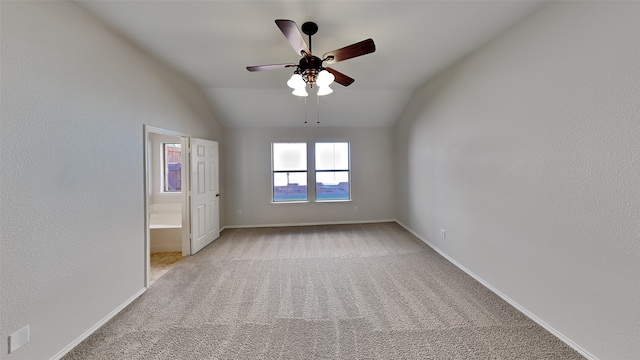 unfurnished room with light colored carpet, vaulted ceiling, and ceiling fan