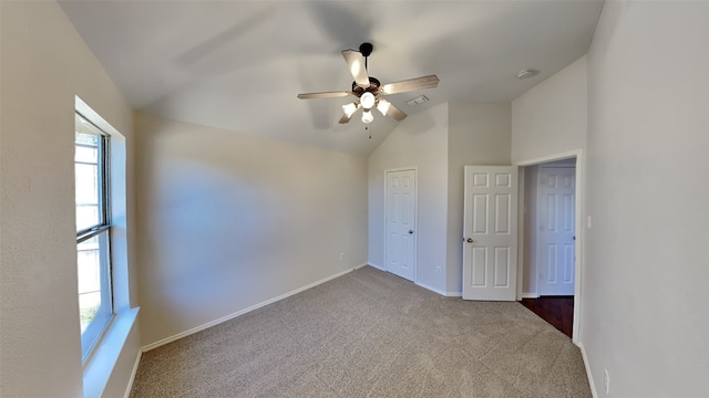 unfurnished bedroom with multiple windows, ceiling fan, light colored carpet, and lofted ceiling