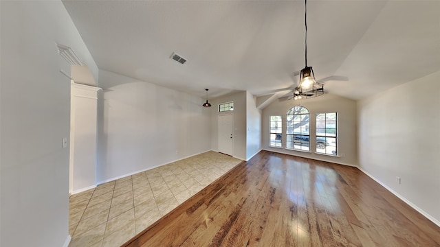 unfurnished living room featuring vaulted ceiling, light hardwood / wood-style flooring, and ceiling fan