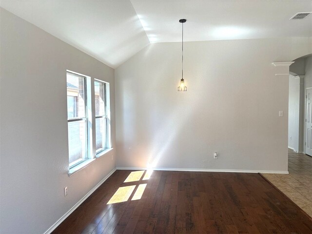 spare room with light hardwood / wood-style floors, ornate columns, and lofted ceiling