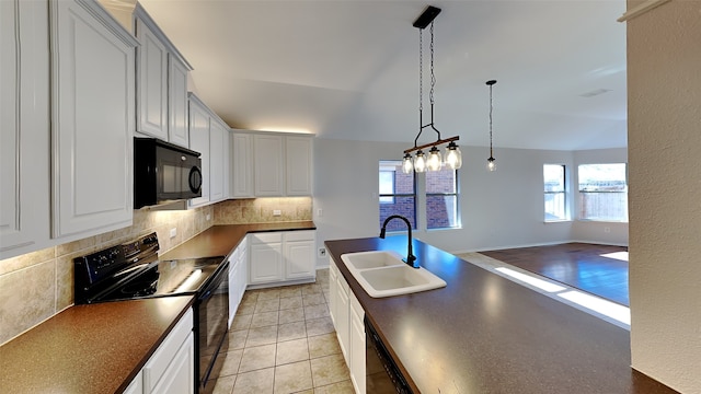 kitchen featuring sink, hanging light fixtures, tasteful backsplash, light tile patterned floors, and black appliances