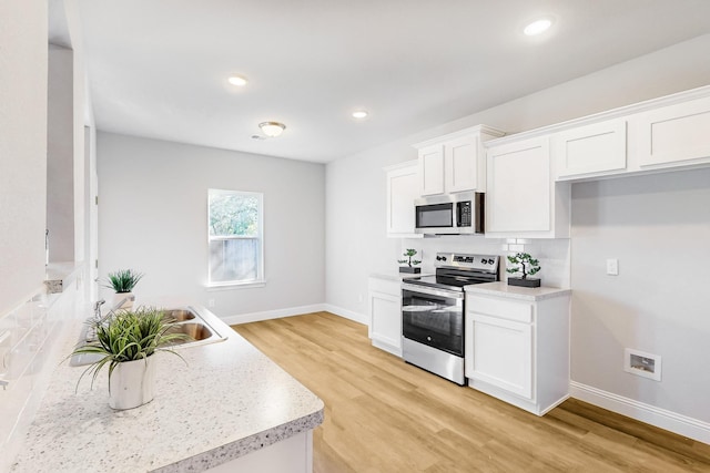 kitchen with stainless steel appliances, white cabinetry, tasteful backsplash, and light hardwood / wood-style floors