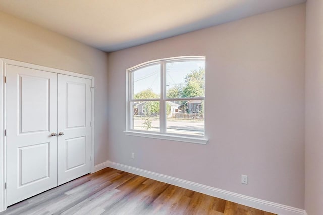 unfurnished bedroom featuring light hardwood / wood-style floors and a closet