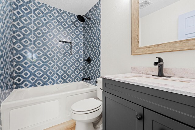 full bathroom with vanity, a textured ceiling, toilet, and washtub / shower combination