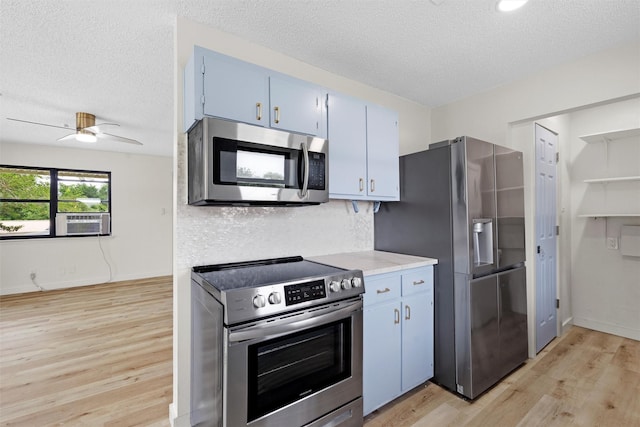 kitchen featuring appliances with stainless steel finishes, light wood-type flooring, a textured ceiling, ceiling fan, and cooling unit