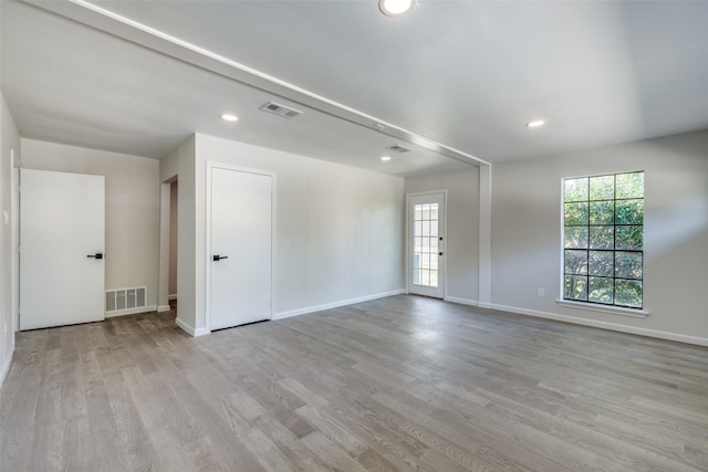 empty room with light wood-type flooring and a wealth of natural light