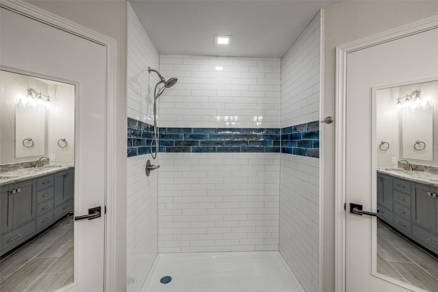 bathroom with a tile shower and vanity