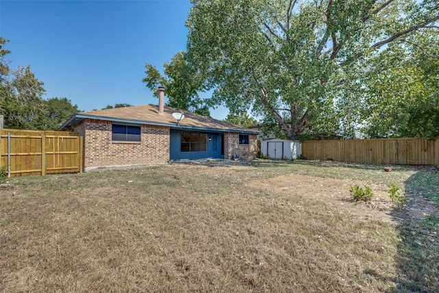 back of property with a lawn and a storage shed