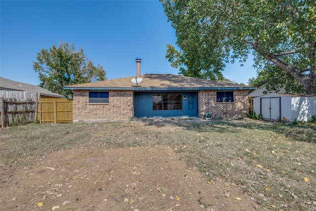 back of property featuring a yard and a storage shed