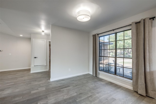 empty room featuring plenty of natural light and hardwood / wood-style floors