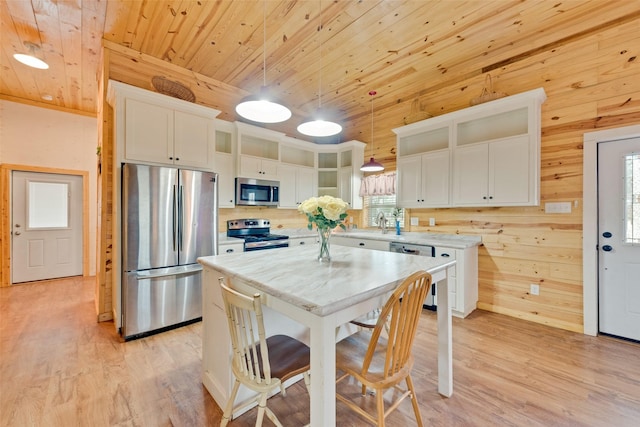 kitchen featuring pendant lighting, a center island, appliances with stainless steel finishes, and wooden ceiling