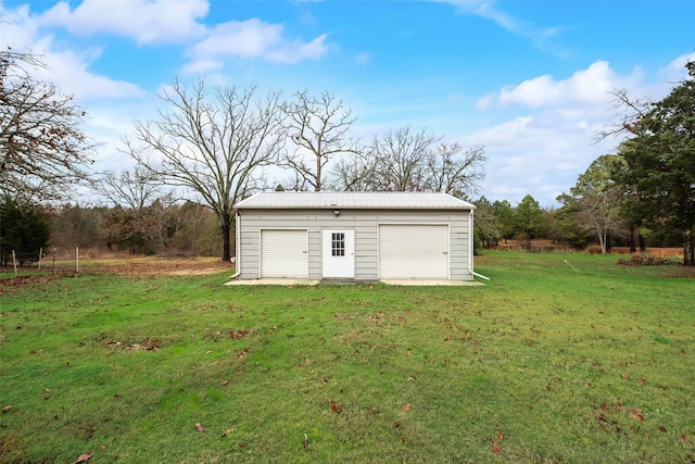 view of outdoor structure with a yard and a garage