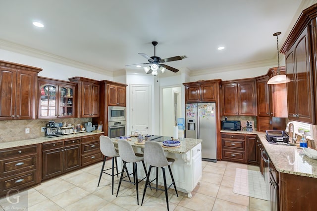 kitchen featuring a kitchen breakfast bar, tasteful backsplash, stainless steel appliances, a center island, and hanging light fixtures