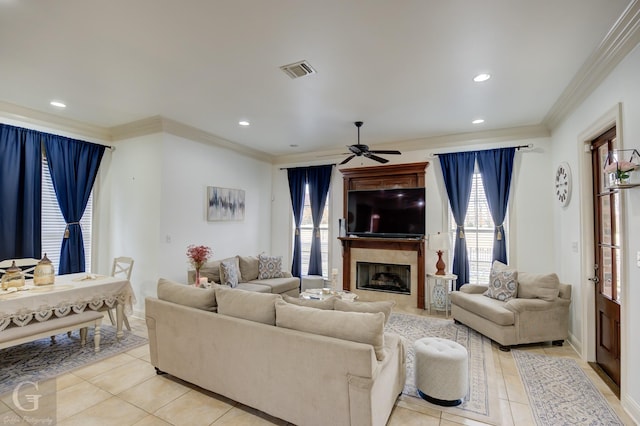 tiled living room with ceiling fan and ornamental molding