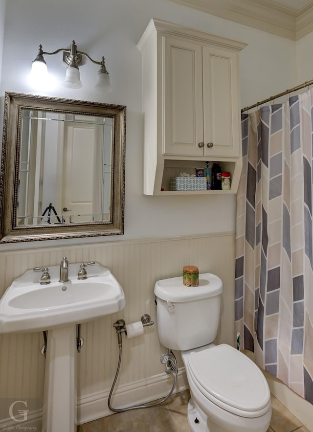 bathroom featuring sink, a shower with curtain, tile patterned floors, crown molding, and toilet