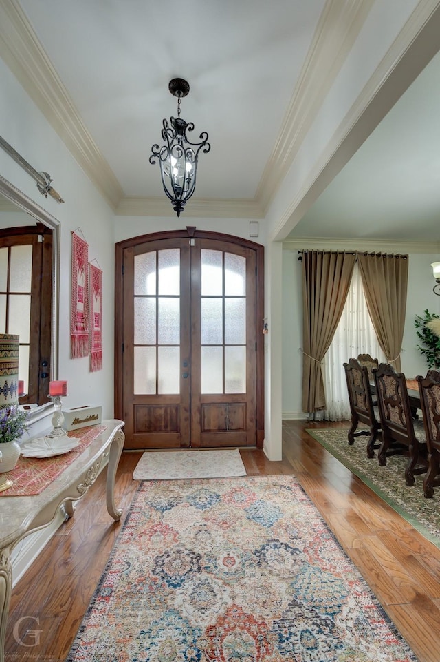 entryway with hardwood / wood-style flooring, crown molding, and french doors