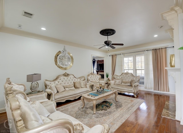 living room with ornamental molding, ceiling fan, and dark hardwood / wood-style flooring