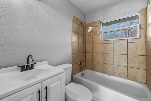 full bathroom with tiled shower / bath, vanity, and toilet