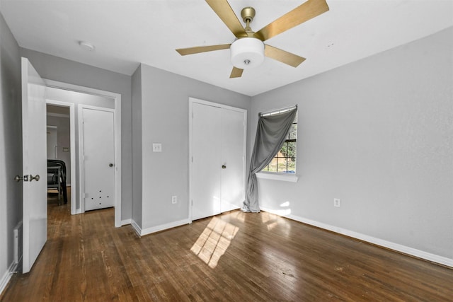 unfurnished bedroom featuring ceiling fan, a closet, and dark wood-type flooring