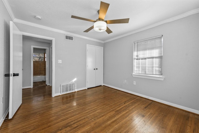 unfurnished bedroom with dark hardwood / wood-style flooring, a closet, ceiling fan, and crown molding