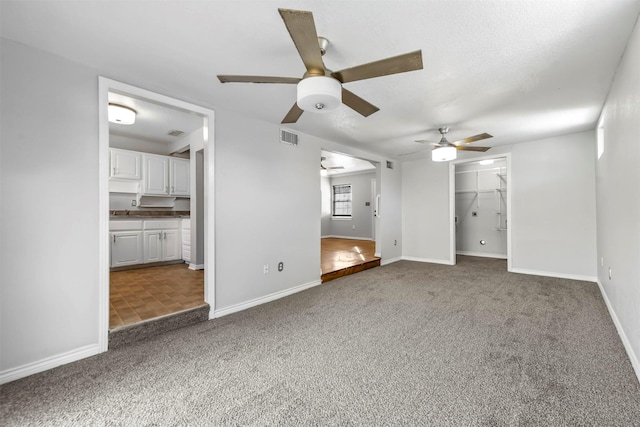 unfurnished living room with carpet flooring and ceiling fan