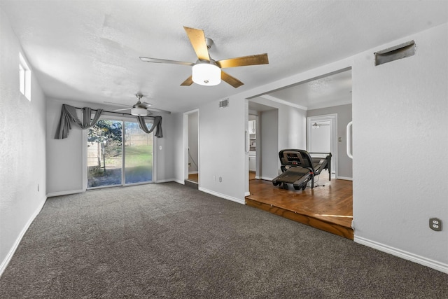 unfurnished living room with ceiling fan, a textured ceiling, and dark colored carpet