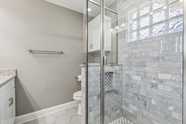 bathroom featuring vanity, tile patterned flooring, a shower with door, and toilet